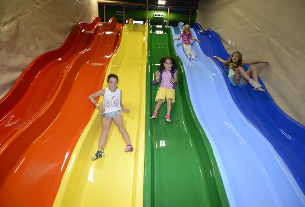 kids sliding down a rainbow slide