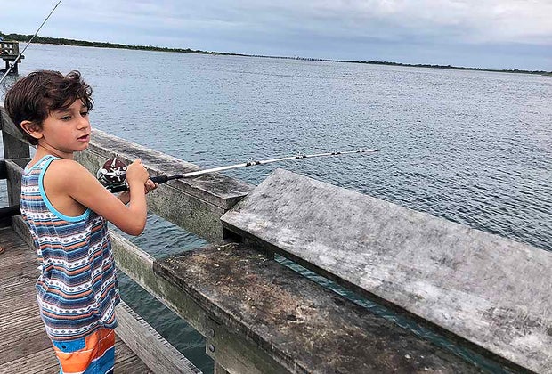 boy fishing off a pier