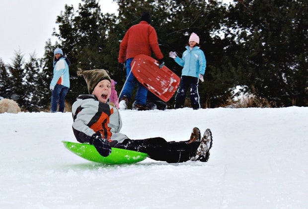 Child sledding on Danehy Park, one of the best sledding hills around Boston.