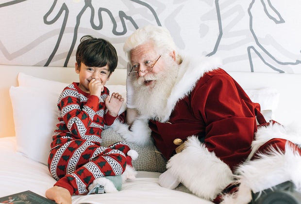 Santa visitng a boy who is in his pajamas
