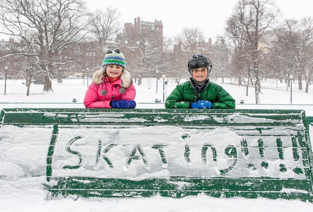 Image of children outdoors in Boston with a hand-written skating sign