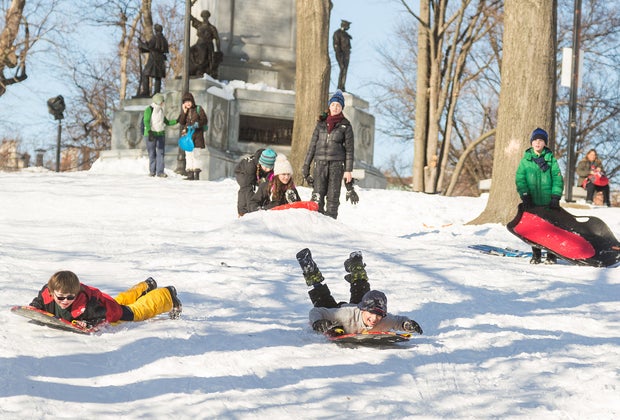 Photo of kids sledding on Flagstaff hill in Boston.
