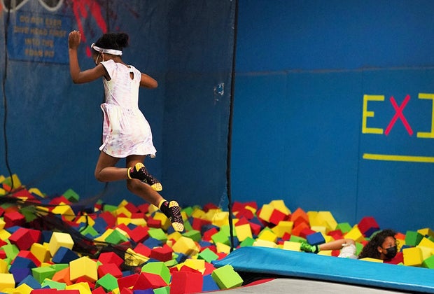 Girl jumping into a foam pit at a trampoline park near NYC
