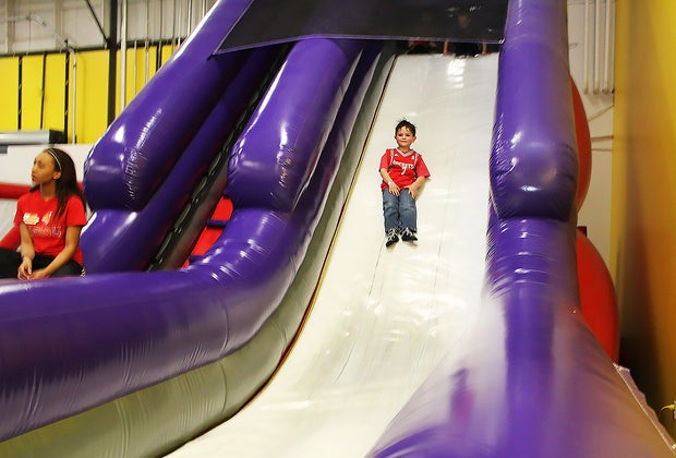 Boy sliding down a bouncy slide at BounceU, a trampoline park near NYC