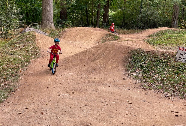 kids riding bikes and jumping on a dirt track