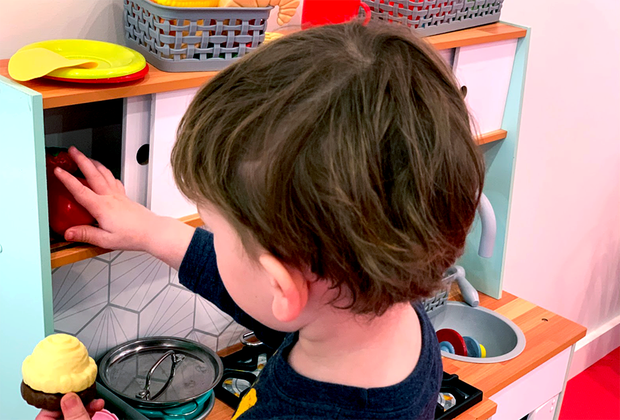 child playing in toy kitchen