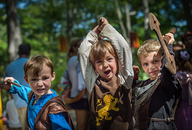 New York Renaissance Faire boys in renaissance clothing holding swords