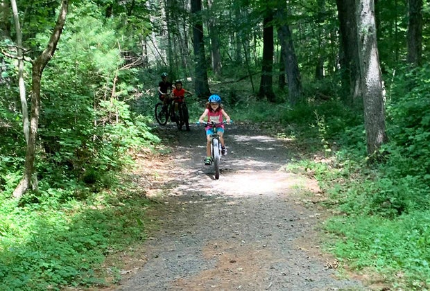 Camping near NYC: Child riding bike on a path through the woods at Dingmans Campground