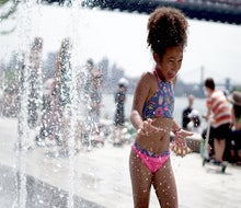 The splash pad in Domino Park puts a smile on faces young and old. Photo by Jody Mercier