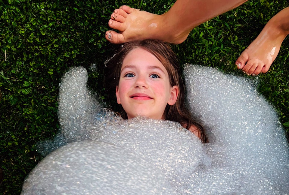 Getting buried in bubbles is much less messy than getting buried in sand! Photo by Ally Noel for Mommy Poppins