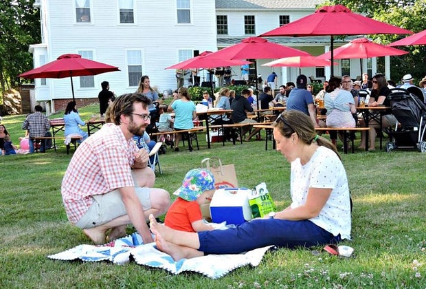 Boston Breweries: Image of a family relaxing in the grass at a Notch Brewery beer garden.