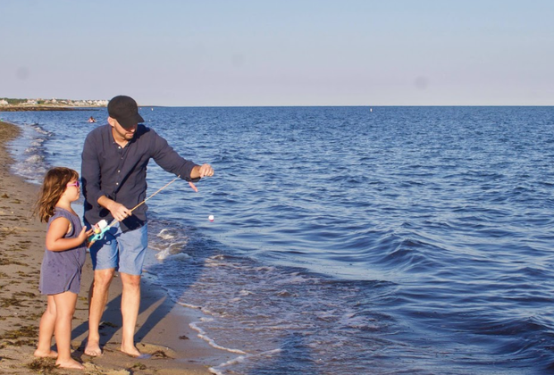 Photo of father and daughter fishing on a Cape Cod beach.