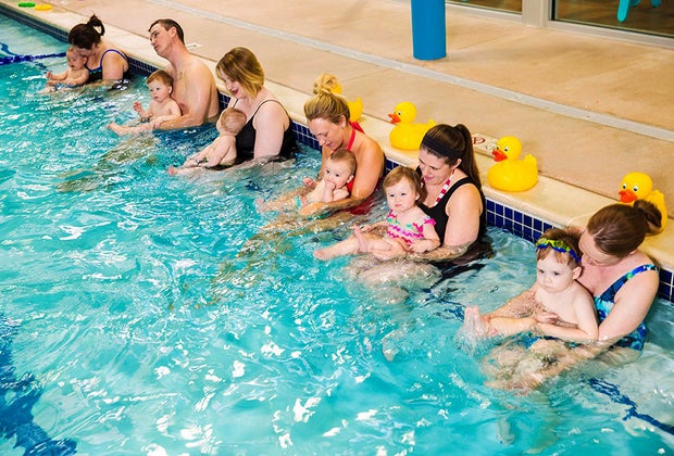 moms and dads and babies in pool for swim class