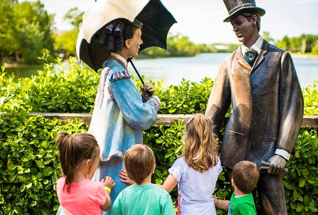 kids look at statues with a beautiful pond at the Grounds for Sculpture