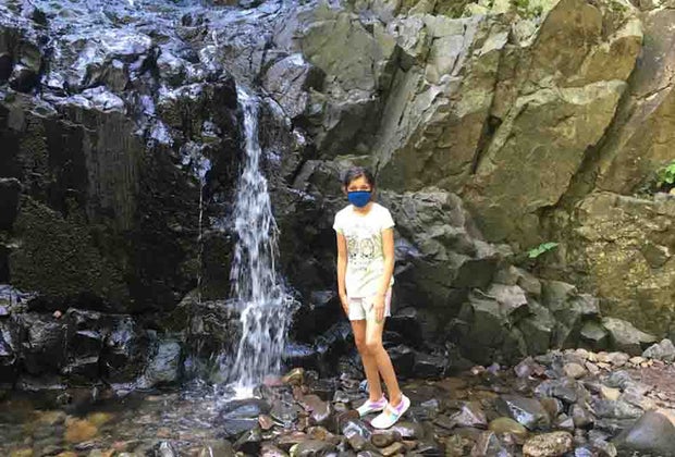 Girl stands in the rocks near Hemlock Falls