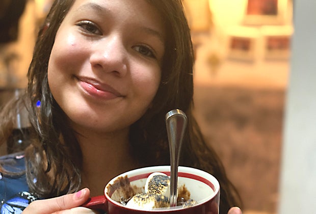 Smiling girl holding s'mores mug cake