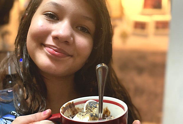Smiling girl holding s'mores mug cake