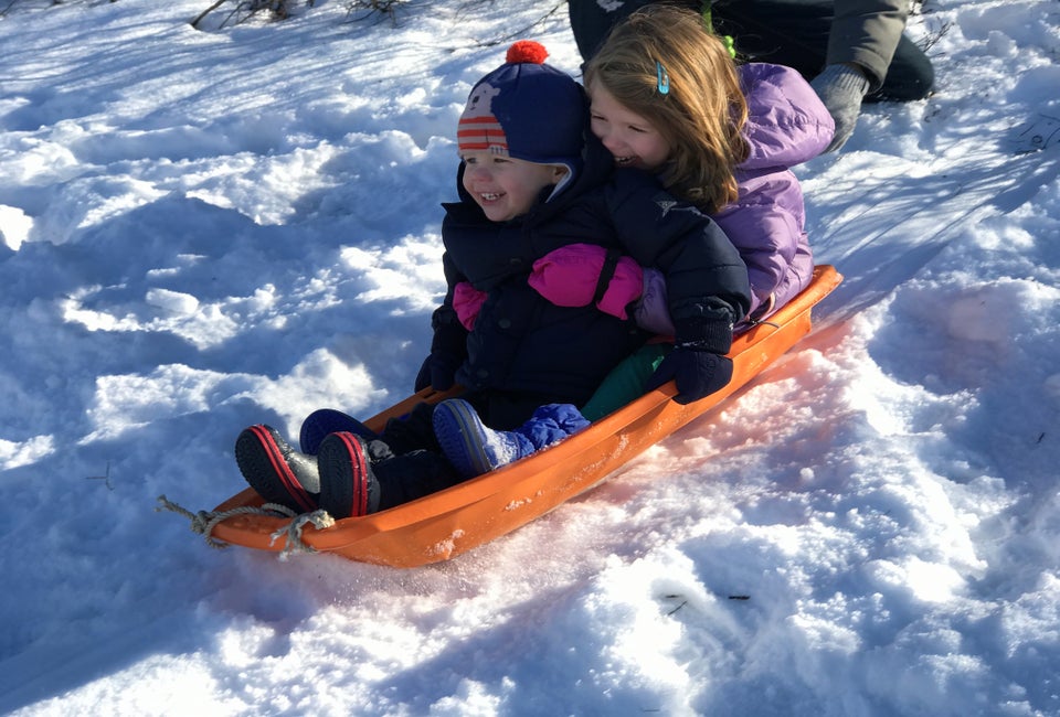 Sledding is one of the best ways to enjoy a snow day with kids!  Photo by Mommy Poppins
