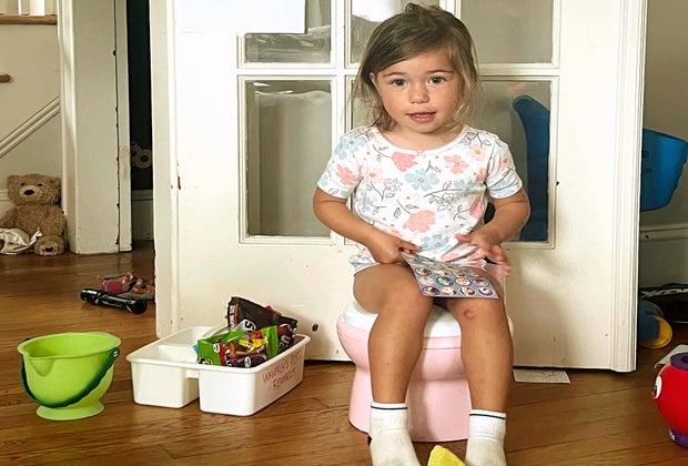 girl on potty with potty basket and treat bucket