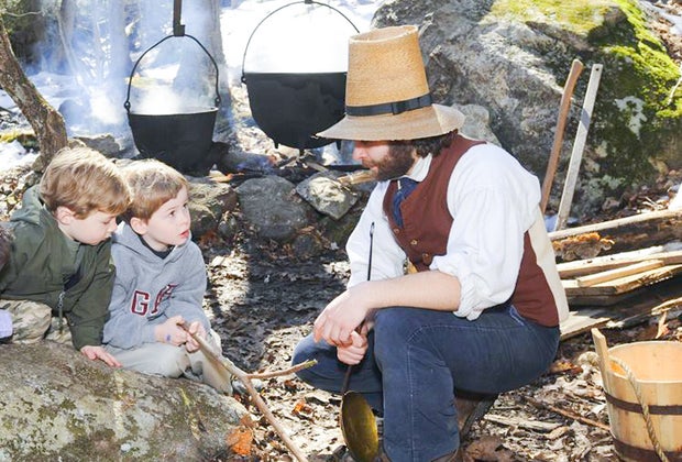 Image of actors in period costume making maple syrup in Sturbridge.