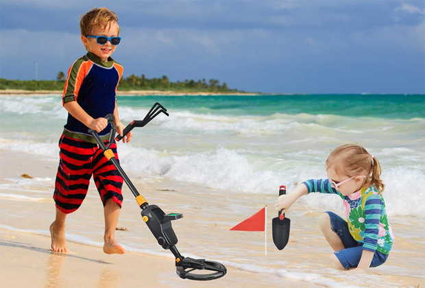 kids using metal detector on the beach