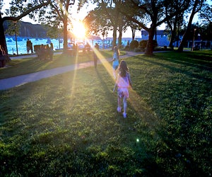 Families gather at Northport Park as the sun sets on the scenic Northport Harbor. Photo by the author