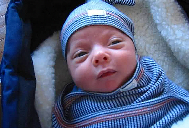 newborn baby in swaddling blanket and matching cap