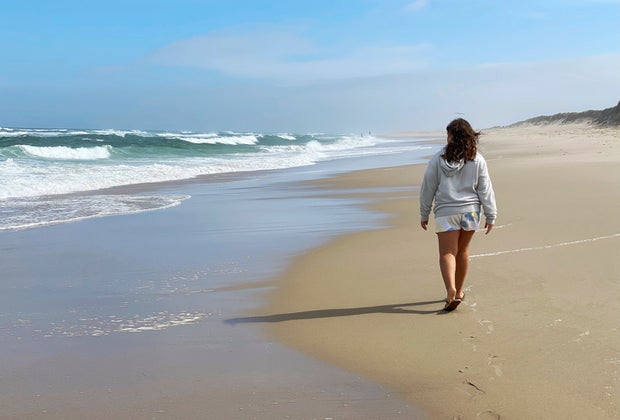 Picture of a person walking along the shore of a Cape Cod beach.