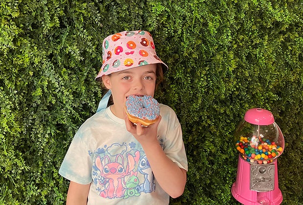 Kid eating a donut wearing a donut hat - Photo by Kelly Patino for Mommy Poppins National Donut Day