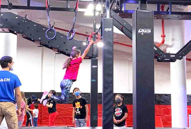 girl swinging on rings at New York Ninja Academy NYC Birthdays