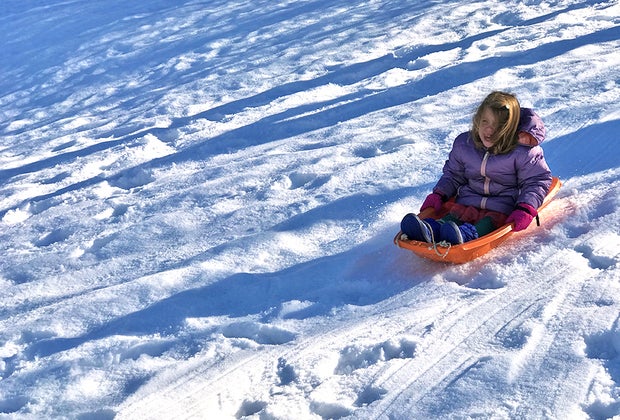 Best sledding hills in New Jersey: Little girl on a sled