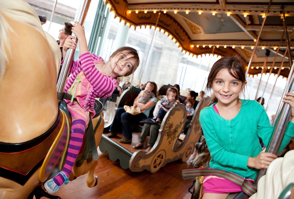 NYC park attractions, like Jane's Carousel in Brooklyn Bride Park, make great, budget-friendly spots to host a birthday party. Photo courtesy of the carousel