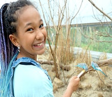 Budgie Landing invites guests into the habitat of 1,000 free-flying mini-parrots for a chance to feed them from a stick. 