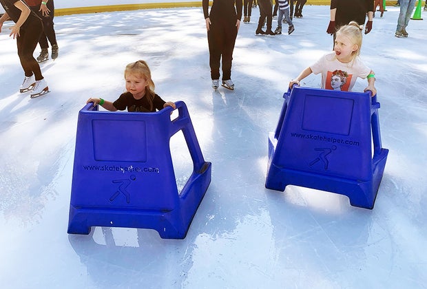 Ice skating at Wollman Rink in Central Park with kids: Close up of two girls with skate aids