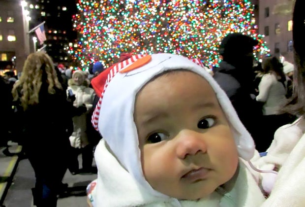 Best things to do in NYC with babies: Baby poses in front of Rockefeller Center Christmass Tree