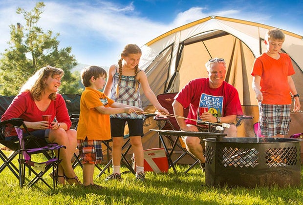 Photo of a family roasting marshmallows at a campsite