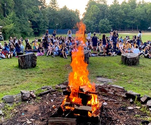 Gather by the fire at Camp Timber Tops. Photo courtesy of the camp