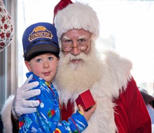 Santa brings holiday cheer (and a special gift) to each of his  young passengers. Photo by Robert Berard courtesy of Blackstone Valley Tourism Council