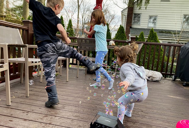 kids playing with bubbles on a deck