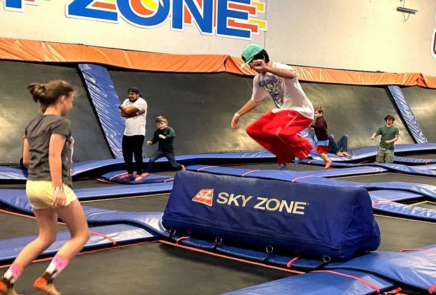 kids of all ages jump and try tricks at sky zone trampoline park