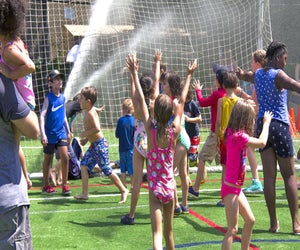 Slip and slide your way to smiles during Asphalt Green's Sprinkler Day. Photo courtesy of Asphalt Green