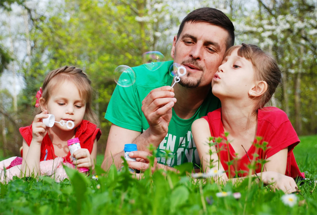 Stress Relief Activities for Kids: dad blowing bubbles with kids