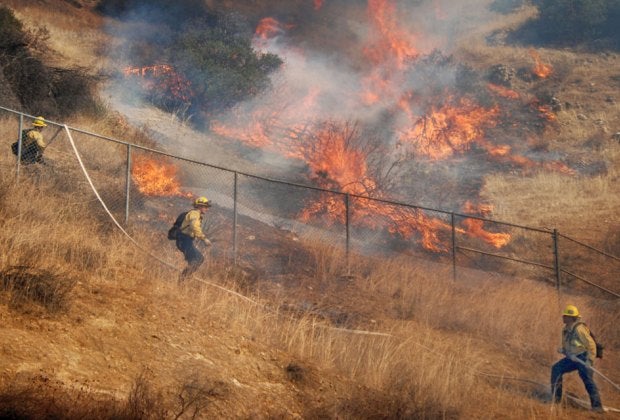 Firefighters battling the Woolsey Wildfire. Photo by Mike Meadows courtesy of Los Angeles Fire Department