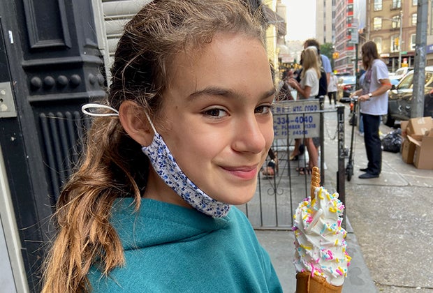 Taiyaki NYC. girl eating a unicorn ice cream in a fish shaped cone