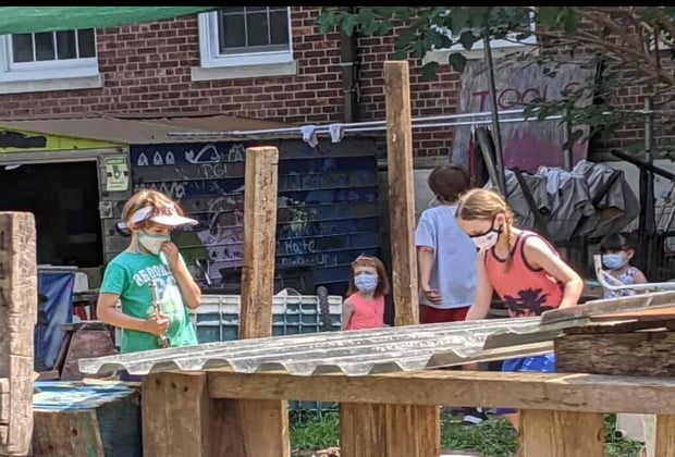 Masked children play in The Yard, Governors Island's adventure playground