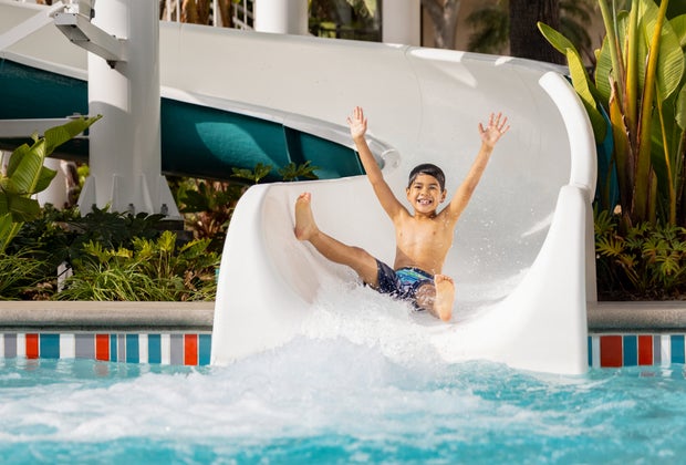 boy slides down The Twister into the pool with a huge smile